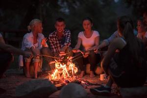 junge freunde, die sich am lagerfeuer entspannen foto