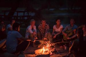 junge freunde, die sich am lagerfeuer entspannen foto