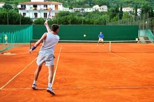 mann spielt tennis im freien foto