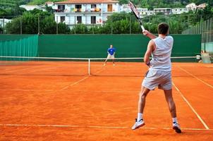 mann spielt tennis im freien foto