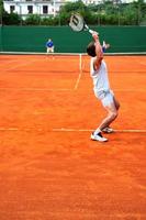 mann spielt tennis im freien foto