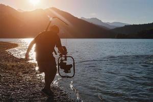 Videofilmer, der einen Triathlon-Schwimmsportler fotografiert foto