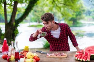 Mann Gewürze auf rohes Fleisch zum Grillen setzen foto