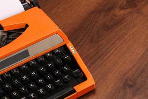 orange Vintage Schreibmaschine auf dem Holz foto