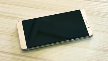 Bild Smartphone auf weißem Holztisch. foto