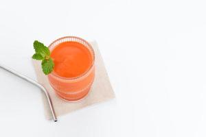 ein Glas frischer Karottensaft, sehr gut für die Gesundheit. serviert im Glas auf weißem Hintergrund foto