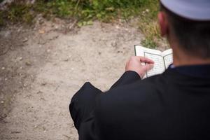 Koran-Heiligbuch-Lesung durch Imam bei islamischer Beerdigung foto