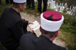 Koran-Heiligbuch-Lesung durch Imam bei islamischer Beerdigung foto