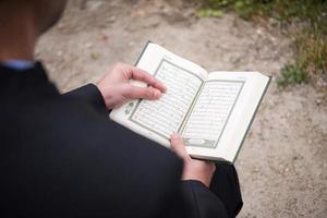 Koran-Heiligbuch-Lesung durch Imam bei islamischer Beerdigung foto