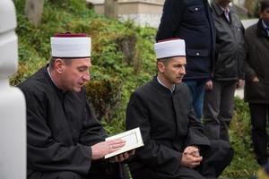 Koran-Heiligbuch-Lesung durch Imam bei islamischer Beerdigung foto