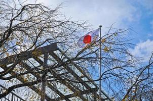 japan-flagge, die im herbst blauer himmel japan fliegt foto