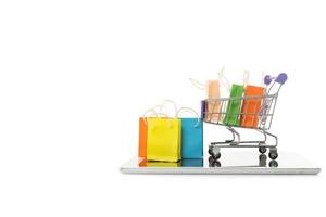 Einkaufstasche in einem Trolley mit Tablet auf weißem Hintergrund, Online-Shopping oder E-Commerce-Konzept foto