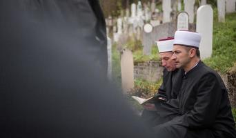Koran-Heiligbuch-Lesung durch Imam bei islamischer Beerdigung foto