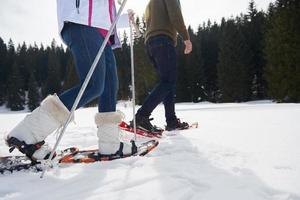 paar, das spaß hat und in schneeschuhen geht foto