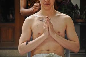 Haareschneiden während der Meditation in einer Ordination zum thailändischen Mönch foto