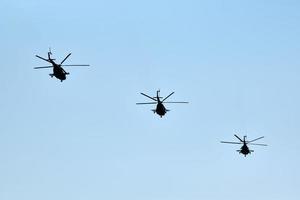 Militärhubschrauber, die am blauen Himmel fliegen und Demonstrationsflüge, Kunstflugstaffeln, Flugschau durchführen foto