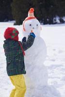 Junge macht Schneemann foto