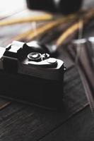 Negativfilm auf einem schwarzen Holztisch und 2 Vintage-Filmkameras. foto