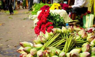 lotus und rote rose werden in einer reihe gehalten, um sie auf dem howrah-blumenmarkt, dem blumenmarkt von kalkutta und dem mullick ghat zu verkaufen foto