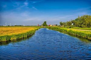 Holländische Landschaft mit einem Kanal und Grasfeldern mit Spiegelreflex foto