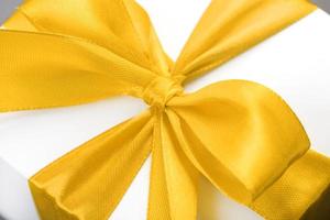 gelbe Schleife auf einem Geschenk aus Stoff auf weißem Hintergrund. foto