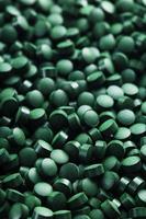 Grüne Tabletten aus vegetarischem Spirulina-Nahrungsergänzungsmittel foto