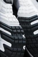 Die schwarz-weiße Sohle von trendigen Sportsneakers ist eine Nahaufnahme im Vollbildmodus. foto