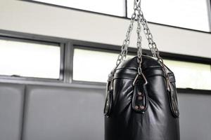 schwarzer Sandsack für Boxer im Fitnessstudio. foto