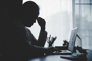 stress geschäftsfrau person von harter arbeit, depression im büro. müde und ängstliche mitarbeiterin mit unzufriedenem problemjob. junge Geschäftsfrau, die traurig vor Laptop-Computer auf Schreibtisch sitzt. foto