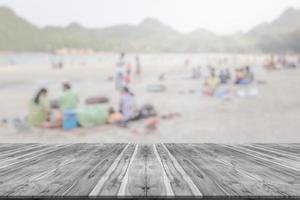 leere holzbrettplatzplattform mit vielen leuten auf dem verschwommenen hintergrund des strandes foto