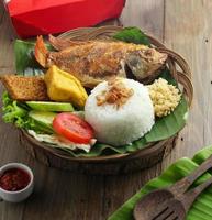 Knusprig gebratener Fisch, serviert mit Reis, Gemüse und Chili foto