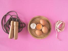 springseil, eier und maßband auf rosa hintergrund. foto