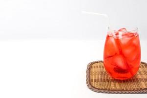 roter Cocktail mit Eiswürfeln auf weißem Hintergrund. Freiraum für Text foto