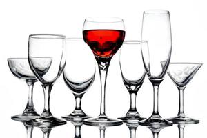 Collage aus leeren Gläsern mit Wein auf weißem Hintergrund. foto