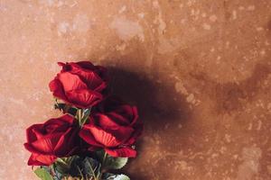 Strauß roter Rosen auf braunem Grunge-Board-Hintergrund. Freiraum für Text foto