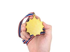 Hand, die Goldmedaille auf weißem Hintergrund hält foto