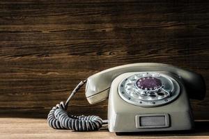altes Telefon auf Holztischhintergrund. foto