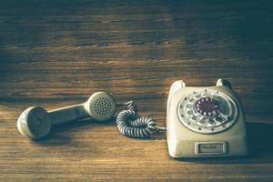 altes Telefon auf Holztischhintergrund. Vintage-Ton foto