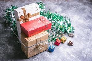 Geschenkboxen und Weihnachtsdekoration auf grauem Grunge-Hintergrund foto