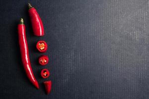 frischer roter Chilipapper auf schwarzem Hintergrund. Freiraum für Text foto