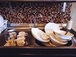 Viele Küchenutensilien zum Reinigen in einer Spüle. foto