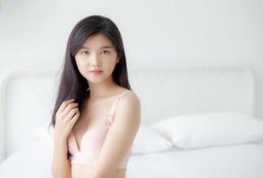 schönes porträt junge asiatische frau sexy in unterwäsche figur fit entspannen mit verführerisch im schlafzimmer, schönheit asia mädchen körper schlank in dessous selbstbewusst und glücklich stehen im schlafzimmer, lifestyle-konzept. foto