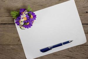 ein blatt papier mit einem stift auf einem hölzernen schreibtisch foto