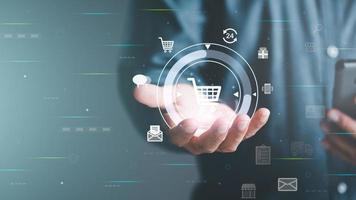 E-Commerce-Konzept und Online-Verkaufswebsite, Einzelhandelsgeschäft mit Cyberspace-Technologie zur Kommunikation zwischen Ladenbesitzer und Kunde. Ein virtueller Einkaufswagen in den Händen eines Mannes. foto