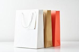 drei bunte Papier-Einkaufstüte auf weißem Hintergrund foto