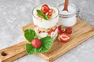 Müsli oder Joghurt mit Erdbeeren im Glas, frischen Beeren und Glas foto