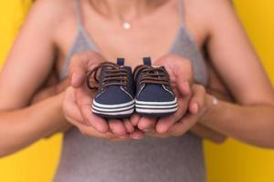 Paar, das neugeborene Babyschuhe hält foto