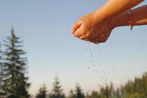 frisches wasser, das auf kinderhände fällt foto