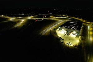 Nachtluftaufnahme der britischen Autobahnen mit beleuchteten Straßen und Verkehr. Aufnahmen von Autobahnen, die mit der Drohnenkamera über Milton Keynes und Autobahnen von England in dunkler Nacht aufgenommen wurden foto