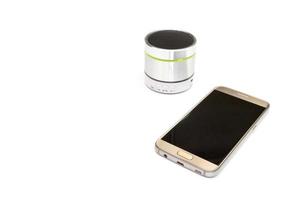 Handy und silberner Bluetooth-Lautsprecher isoliert auf weißem Hintergrund foto